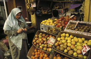 Woman counting out cash to buy fruit at a stall in the market behind Al-Azhar Mosque in the heart of the Islamic City.